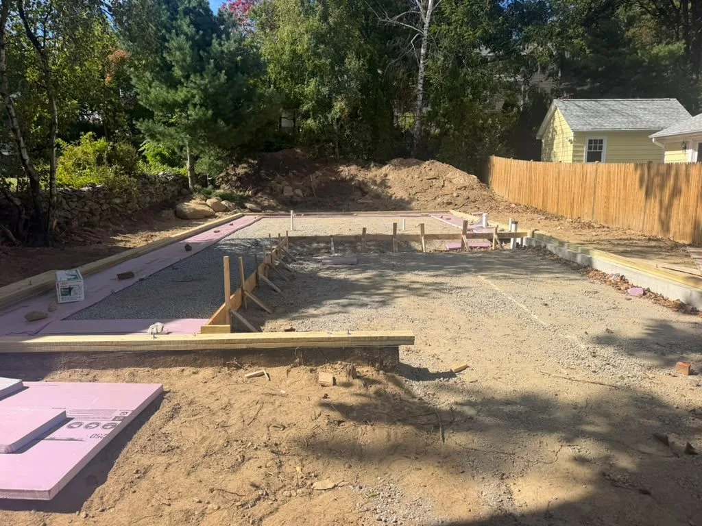 Rigid foam insulation and forms laid out on a compacted base before a slab pour