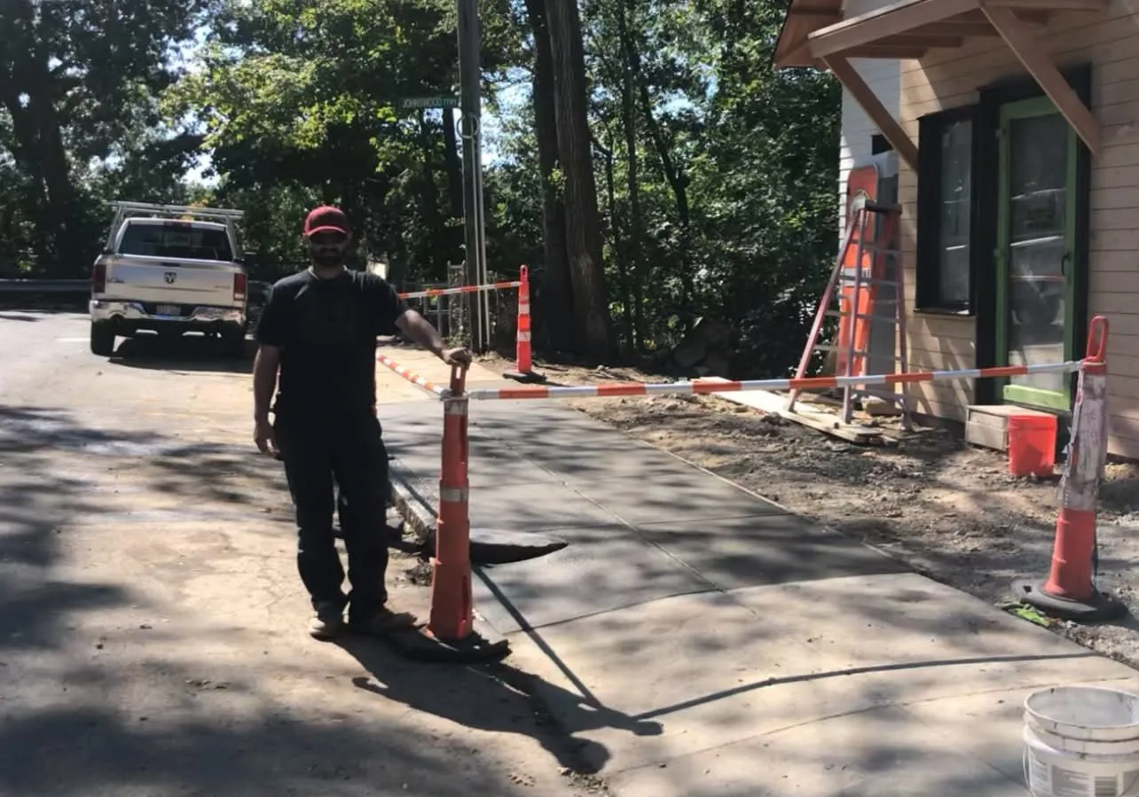 Freshly poured concrete flatwork next to a house